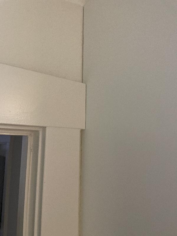 On the left side of the fourth cabinet, right up against the door trim. 