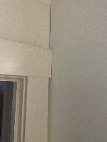 On the left side of the fourth cabinet, right up against the door trim. 