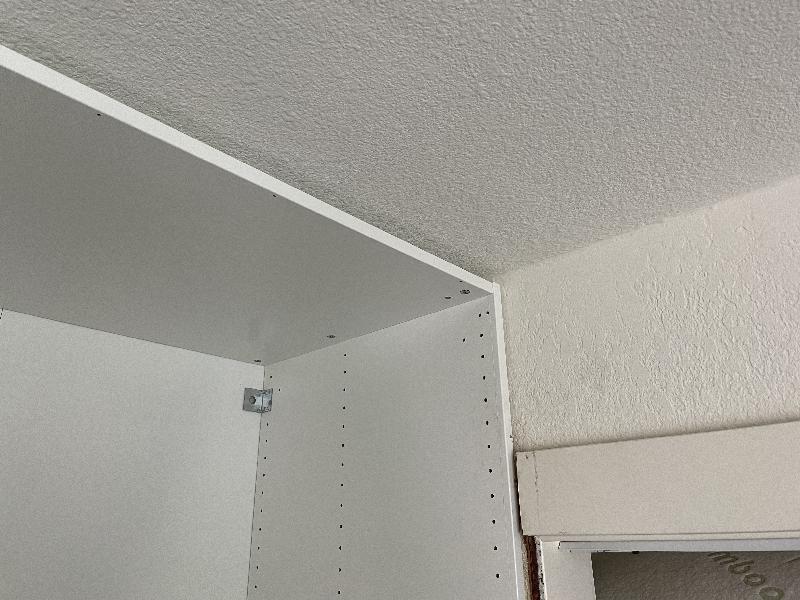 Closet top trim cut back so the cabinets are flush against the wall. 