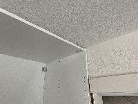 Closet top trim cut back so the cabinets are flush against the wall. 